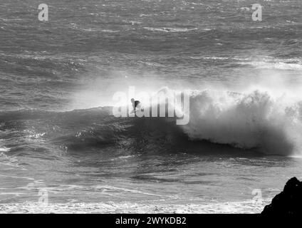 Wave board o body board navigando in enormi breakers a Kynance Cove, Cornovaglia. Affrontare le onde. Foto Stock