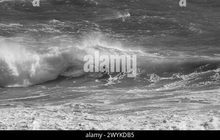 Wave board o body board navigando in enormi breakers a Kynance Cove, Cornovaglia. Affrontare le onde. Foto Stock