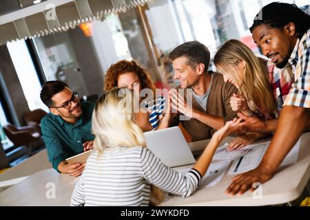 Diversi colleghi d'affari si riuniscono in una sessione di brainstorming discutere insieme le statistiche finanziarie Foto Stock