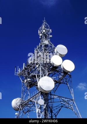 Montante per comunicazioni su strada con impianti di telecomunicazioni su sfondo blu, Inghilterra, Regno Unito Foto Stock