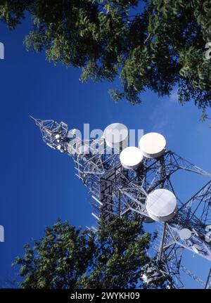 Montante per comunicazioni su strada con impianti di telecomunicazioni su sfondo blu, Inghilterra, Regno Unito Foto Stock