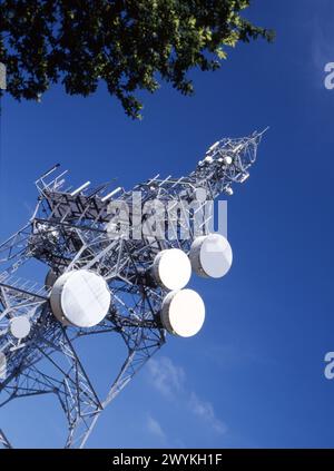 Montante per comunicazioni su strada con impianti di telecomunicazioni su sfondo blu, Inghilterra, Regno Unito Foto Stock