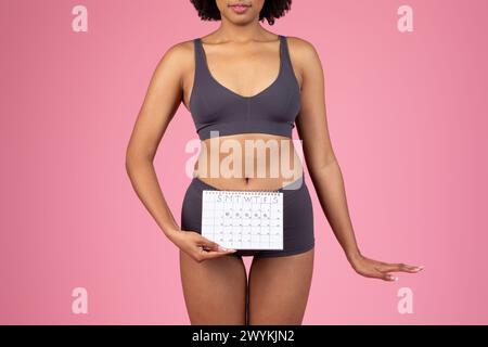 Giovane donna con un calendario di periodi Foto Stock