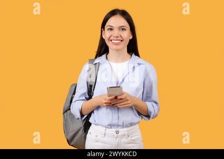 Giovane donna con telefono che sembra piacevolmente sorpresa Foto Stock