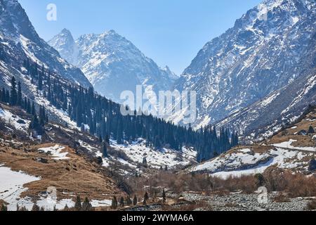 Paesaggio primaverile di una valle di montagna. Montagne innevate nel parco nazionale di Ala-Archa, Kirghizistan. Inizio della stagione escursionistica e trekking. Foto Stock