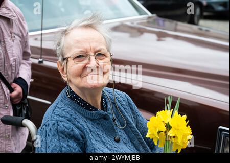 Donna di 85 anni seduta in sedia a rotelle con fiori, Tienen, Belgio, modello rilasciato Foto Stock