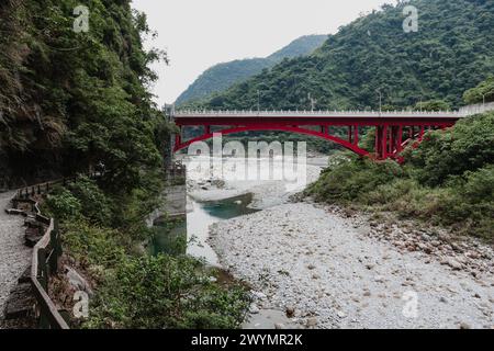 Hualien, Taiwan. 2 luglio 2009. Vista generale del Ponte di Shakadang, un ponte ad arco rosso in acciaio con cento statue di leoni, sul fiume con lo stesso nome attraverso la profonda gola di marmo, vista dal sentiero di Shakadang, nel Parco Nazionale di Taroko, Hualien, Taiwan. Foto Stock