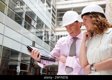 Architetto e client con tablet PC in cantiere. Foto Stock