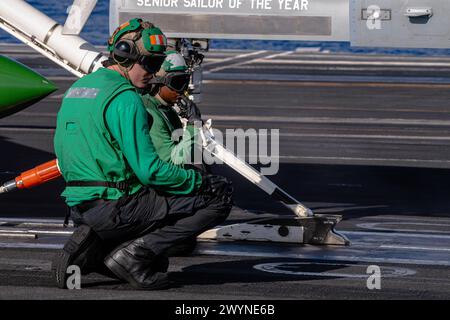 PHILIPPINE SEA (7 aprile 2024) U.S. Navy Aviation Boatswain's Mate (equipaggiamento) 3rd Class Kameron Allen, da Tampa, Flag., fronte, e Aviation Boatswain's Mate (Equipment) Airman Amariah McComb, di Panama City Beach, Flag., preparano un F/A-18E Super Hornet, attaccato al "Fist of the Fleet" dello Strike Fighter Squadron (VFA) 25, per il lancio sul ponte di volo a bordo della portaerei classe Nimitz USS Theodore Roosevelt (CVN 71), 7 aprile 2024. La Theodore Roosevelt, nave ammiraglia del Carrier Strike Group Nine, sta conducendo operazioni di routine nell'area delle operazioni della 7th Fleet. 7esima Foto Stock