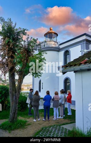 Grupo de Tourist atendiendo la explicaciones de un guia en la Casa del Faro de la Isla Santa Clara, en su interior se encuentra la obra Hondalea, 2020, de la escultora Cristina Iglesias, excavada en el interior de la Casa del Faro vaciada, la obra incorpora la geología y ecología de la Costa vasca y la bravura de las aguas del Mar Cantábrico, Símbolo de la defensa de causas ecológicas y de la Conservación del Medio ambiente, Donostia, San Sebastian, Paesi Baschi, Spagna, Europa. Foto Stock