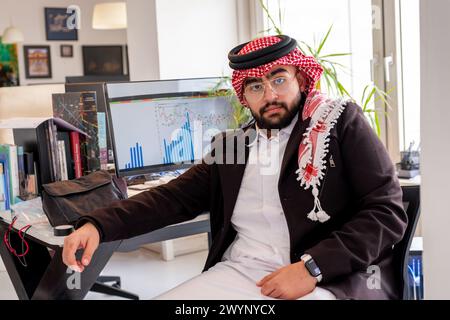 ritratto per uomo arabo sulla sua sedia in ufficio con un sorriso sul viso Foto Stock