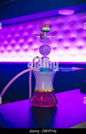 Narghilè in vetro con ciotola e carbone con frutta per il tradizionale relax orientale. Messa a fuoco morbida Foto Stock