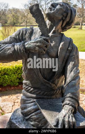 Statua dell'inventore Cherokee dell'alfabeto indiano Sequoyah, che guarda verso l'alto con penna di quill piuma, presso il sito storico Sequoyah's Cabin a Sallisaw, Oklahoma. (USA) Foto Stock
