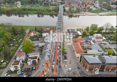 Dresda, Germania. 8 aprile 2024. Le auto sono parcheggiate su una pista ciclabile segnata in rosso al ponte Blaues Wunder sull'Elba (foto scattata con un drone). La pista ciclabile fa parte di una prova con la quale la città vuole testare una nuova divisione dello spazio di traffico. Crediti: Sebastian Kahnert/dpa/Alamy Live News Foto Stock