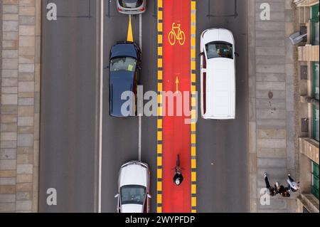 Dresda, Germania. 8 aprile 2024. Le auto sono parcheggiate su una pista ciclabile segnata in rosso al ponte Blaues Wunder sull'Elba (foto scattata con un drone). La pista ciclabile fa parte di una prova con la quale la città vuole testare una nuova divisione dello spazio di traffico. Crediti: Sebastian Kahnert/dpa/Alamy Live News Foto Stock