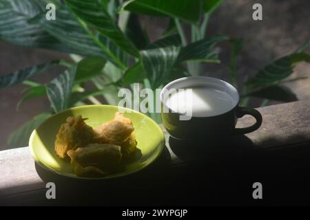 vista ravvicinata delle banane fritte e del caffè caldo. banane fritte accompagnate da caffè caldo la mattina sulla terrazza della casa. Un'abitudine fatta da Ind Foto Stock