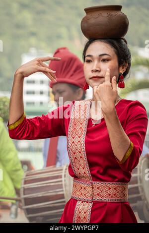 Giovani donne vestite con indumenti tradizionali vietnamiti che eseguono danze tradizionali vietnamite con una pentola di argilla sulla testa. Donne asiatiche - Street perfo Foto Stock