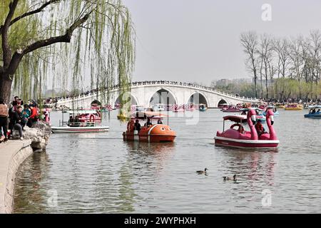 I turisti apprezzano lo scenario primaverile del Parco Yuyuantan in barca durante la vacanza del Festival Qingming a Pechino, Cina, il 5 aprile 2024. Foto Stock