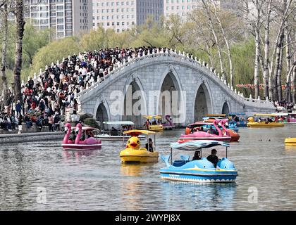I turisti apprezzano lo scenario primaverile del Parco Yuyuantan in barca durante la vacanza del Festival Qingming a Pechino, Cina, il 5 aprile 2024. Foto Stock
