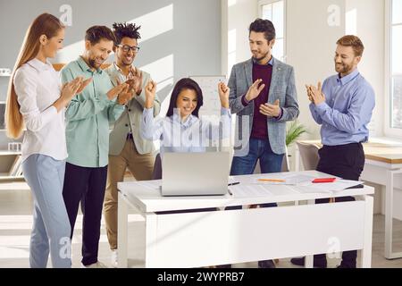 Colleghi che celebrano il successo guardando lo schermo del notebook Foto Stock