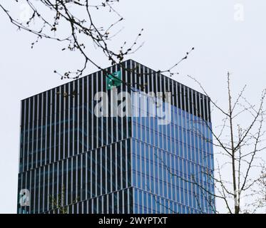 Francoforte, Germania - 31 marzo 2024: Vista ad angolo basso del quartier generale della banca BNP Paribas a Francoforte, che sbircia tra i rami primaverili, simboleggia la crescita e la stabilità Foto Stock