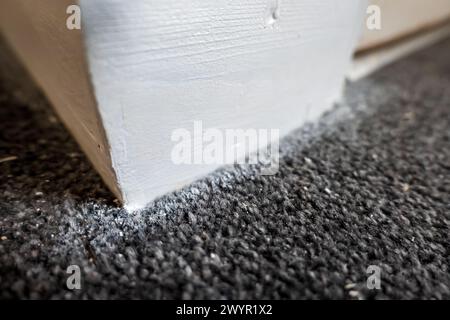 primo piano del battiscopa in legno verniciato durante la ristrutturazione della casa. Foto Stock