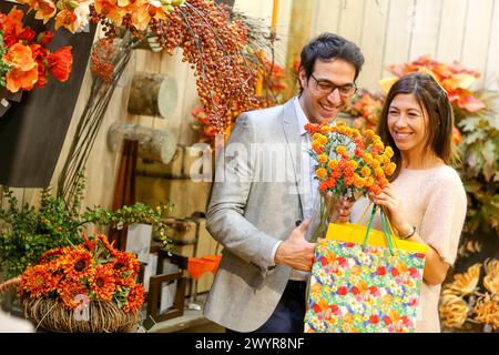 Coppia che acquista ornamenti natalizi nel centro giardino. Foto Stock