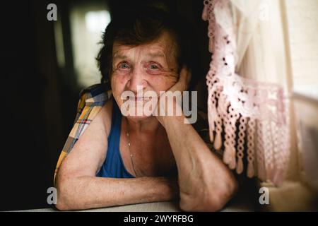 Ritratto a lato del tavolo, donna anziana in primo piano. Foto Stock