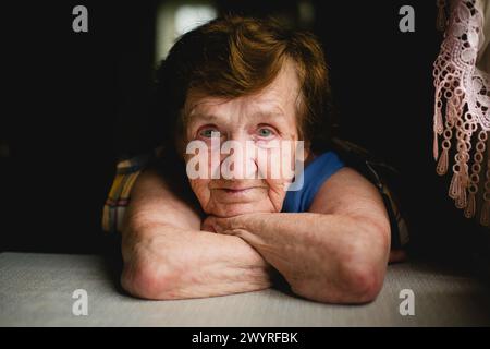 Ritratto primo piano di una donna anziana al tavolo Foto Stock
