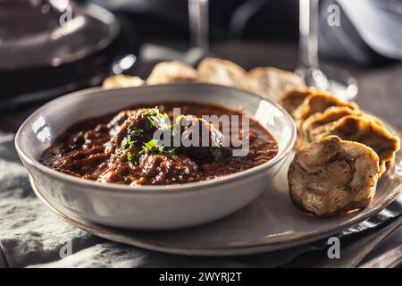 Tradizionale viennese, veleno o gulasch ungherese con gnocchi Karlovy Vary e vino rosso. Foto Stock