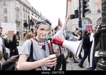 Londra, Regno Unito. 08 APRILE, 2024. Un uomo canta attraverso un megafono mentre Pro Palestine e i membri del gruppo "Youth Demand" Just Stop marciano attraverso il centro di Londra. Credito Milo Chandler/Alamy Live News Foto Stock