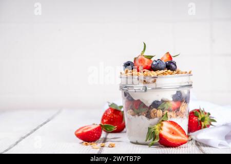 Colazione estiva con muesli e frutti di bosco dessert a strati con yogurt, muesli di avena, fragole, mirtilli su tavola in legno spazio copia Foto Stock