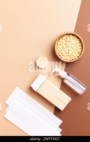 Composizione verticale con rimozione dei peli, strumenti di depilazione su sfondo marrone-beige. Cura del corpo, cura della pelle, trattamento di bellezza. Foto Stock