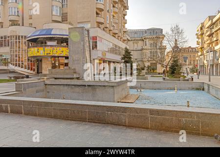 Craiova, Romania - 16 marzo 2024: Fontana presso Piazza Re Ferdinando e Regina Maria nel centro della città durante la giornata di primavera. Foto Stock