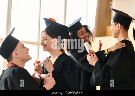 Un gruppo multiculturale di studenti in abiti da laurea e cappelli che celebrano con sorrisi i loro risultati accademici. Foto Stock