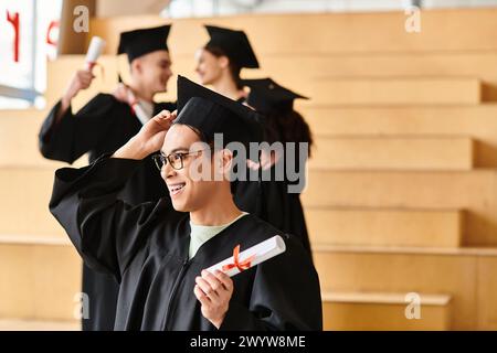 Un uomo eterogeneo con un cappello e un abito in possesso di un diploma celebra la sua laurea in casa. Foto Stock