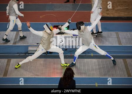 Due schermitori professionisti combattono in pista durante il Campionato nazionale di scherma dell'Ucraina. Kiev - 30 marzo 2024 Foto Stock