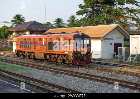 CHA AM, THAILANDIA - 13 DICEMBRE 2018: Locomotiva diesel arancione su una stazione ferroviaria che si trova in una serata di sole Foto Stock