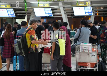 Makassar, Sulawesi meridionale, Indonesia. 8 aprile 2024. L'atmosfera dei passeggeri al banco del check-in dei biglietti presso l'aeroporto internazionale Sultan Hasanuddin di Makassar, affollato di potenziali passeggeri. I passeggeri si preparano a tornare ai loro villaggi per Eid al-Fitr. (Credit Image: © Herwin Bahar/ZUMA Press Wire) SOLO PER USO EDITORIALE! Non per USO commerciale! Foto Stock