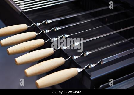 Spiedini di carne con manici in legno nel negozio di articoli per la casa Foto Stock