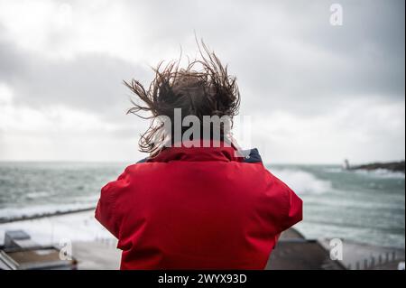 Le Conquet, Francia. 8 aprile 2024. © PHOTOPQR/OUEST FRANCE/GUILLAUME SALIGOT/OUEST-FRANCE ; le Conquet ; 08/04/2024 ; Tempete Pierrick, Coup de vent sur le Finistere en alerte Orange vagues - immersione - sfiati violents sur le littoral . ICI une personne prend des photos les cheveux au vent alors que les vagues s' ecrasent sur la digue du Conquet (Finistere). Foto : Guillaume Saligot/Ouest-France foto di tempesta in bretagna francese l'8 aprile 2024. Crediti: MAXPPP/Alamy Live News Foto Stock