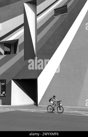 Boy on bike passa davanti alla Towner Art Gallery con le colorate opere d'arte Dance Diagonal dell'artista tedesco Lothar Götz a Eastbourne, East Sussex UK a settembre Foto Stock