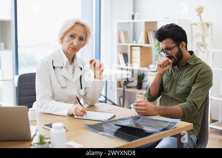 Medico che discute problemi di salute e prescrive farmaci per il trattamento. Foto Stock