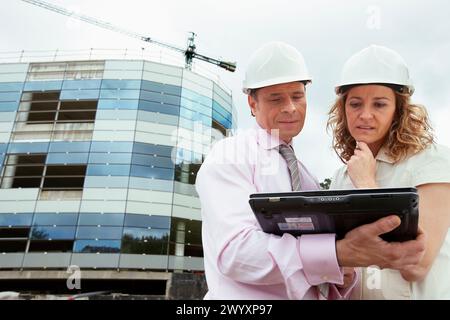 Architetto e client con tablet PC in cantiere. Foto Stock