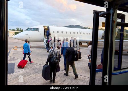 I passeggeri che lasciano l'autobus sulla strada per l'aereo, l'aeroporto di Bilbao, Loiu, Bizkaia, Paesi Baschi, Spagna. Foto Stock