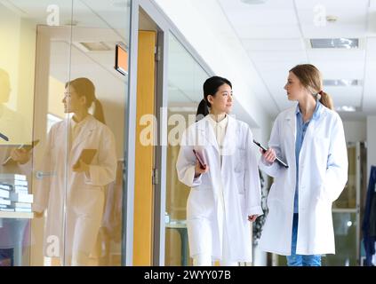 Ricercatori che camminano nel laboratorio del corridoio. Laboratorio di analisi chimica. Servizi tecnologici all'industria. Tecnalia Research & Innovation, Donostia, San Sebastian, Gipuzkoa, Paesi Baschi, Spagna. Foto Stock