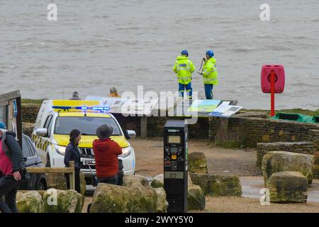 Burton Bradstock, Dorset, Regno Unito. 8 aprile 2024. Meteo nel Regno Unito. Una squadra di ricerca e soccorso della Guardia Costiera HM che tiene d'occhio un grande avvolgicavo in legno che galleggia a 100 metri dalla spiaggia di Burton Bradstock nel Dorset. L'avvolgicavo grande, con un diametro di circa 6 piedi, può causare gravi danni a una piccola imbarcazione da diporto in caso di urto. Negli ultimi giorni, molti detriti di pallet di legno, che potrebbero essere stati lavati da una nave durante la tempesta Kathleen, sono stati lavati a riva sulle spiagge. Crediti fotografici: Graham Hunt/Alamy Live News Foto Stock