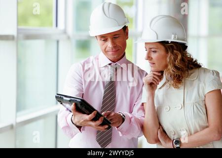 Architetto e client con tablet PC in cantiere. Foto Stock