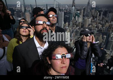 La gente si riunisce a guardare la Solar Eclipse a Edge Hudson Yards l'8 aprile 2024 a New York. Foto Stock
