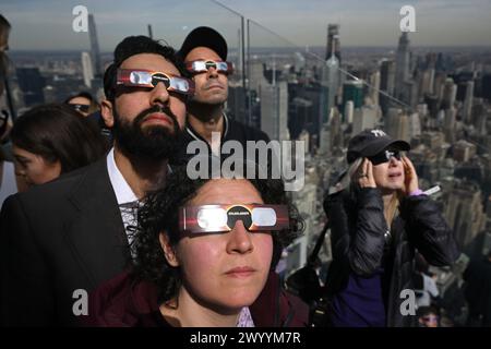La gente si riunisce a guardare la Solar Eclipse a Edge Hudson Yards l'8 aprile 2024 a New York. Foto Stock